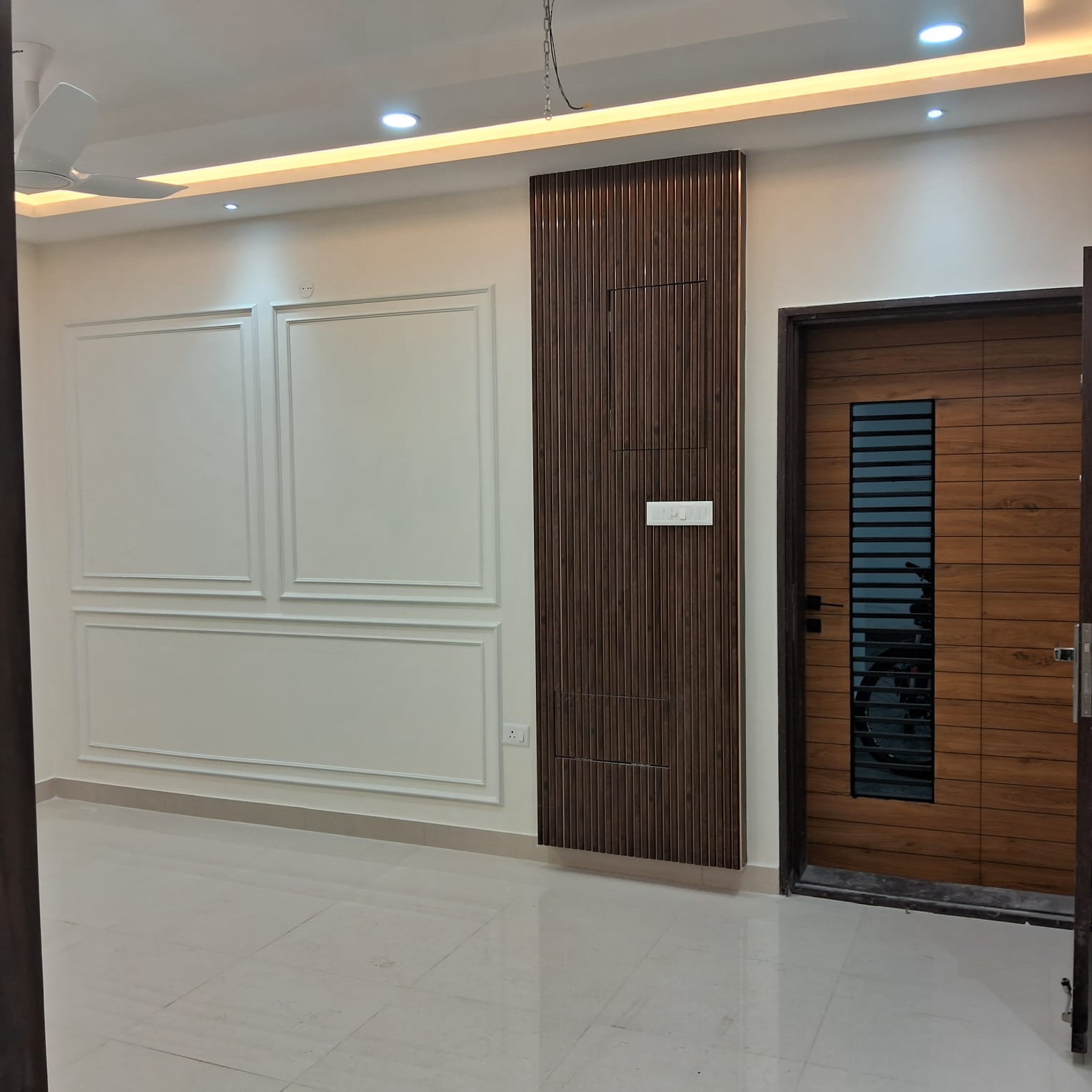 Entry hallway with fluted wood wall panelling beside the front door