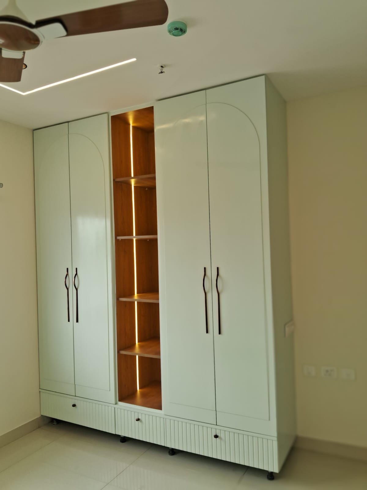 Mint arched-door cabinet with backlit wood interior shelving