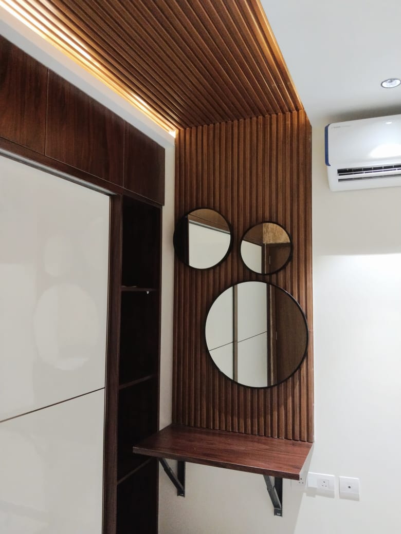 Dressing nook with three round mirrors on a fluted wood panel