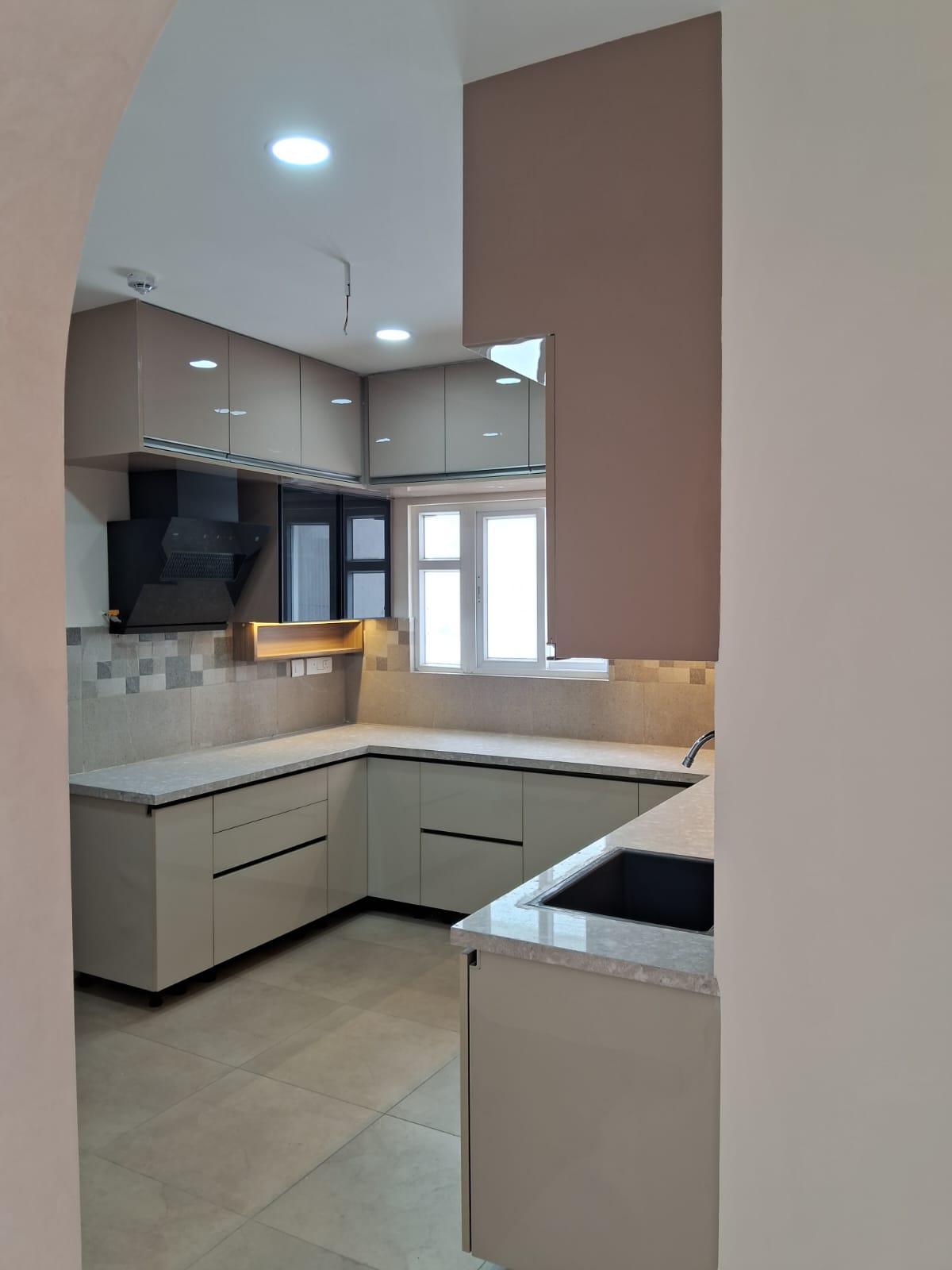 Glossy taupe U-shaped modular kitchen with tiled backsplash