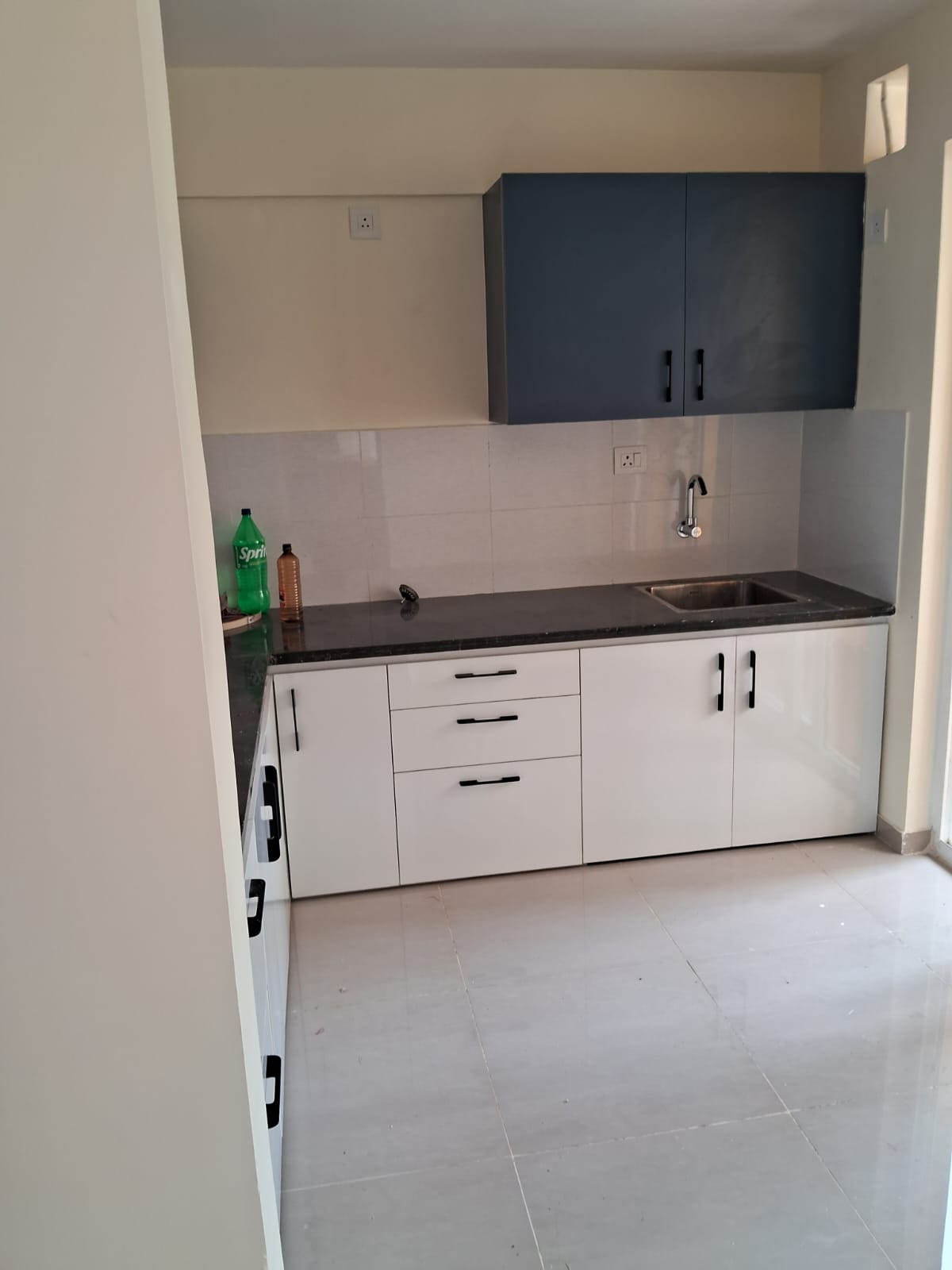 Utility kitchen with navy overhead cabinet and white base units