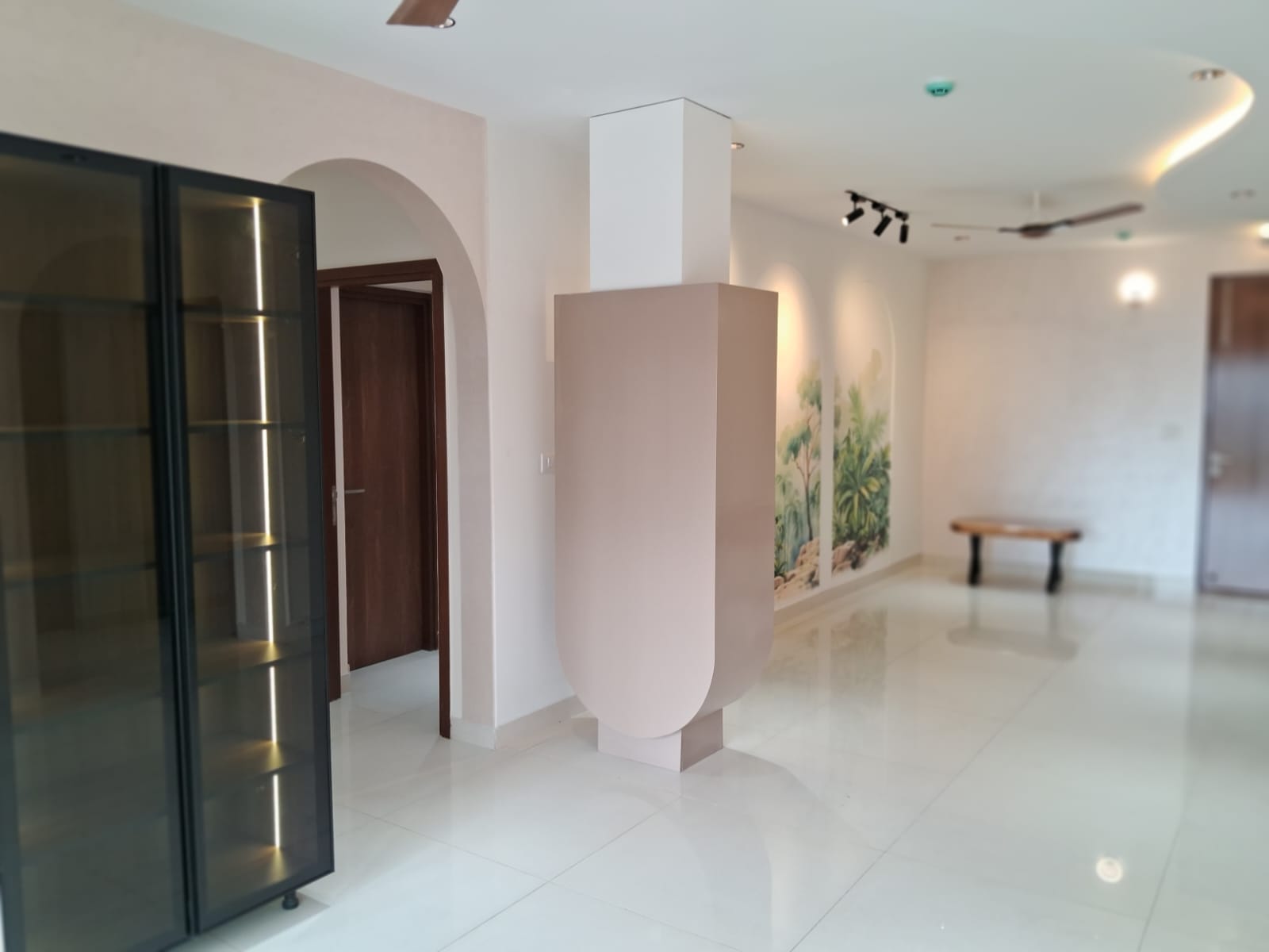 Sculpted blush feature column beside the tropical mural wall